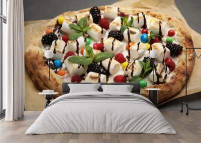 Tasty sweet pizza with berries, marshmallows and candies on black table, closeup Wall mural