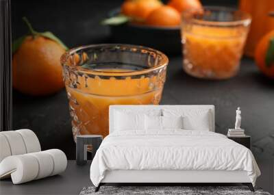 Tasty tangerine liqueur in glasses and fresh citrus fruits on black textured table. Space for text Wall mural