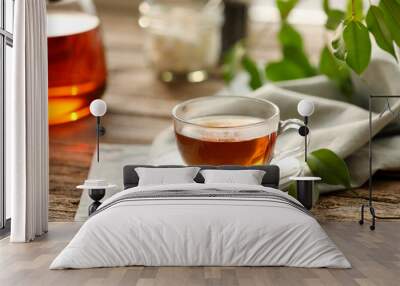 Tasty tea in cup on wooden table, closeup Wall mural