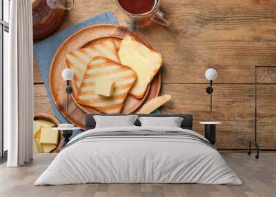 Tasty toasts with butter served on wooden table, flat lay. Space for text Wall mural