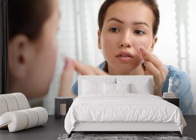 Teen girl applying acne healing patch near mirror in bathroom Wall mural