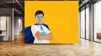 Teenage boy in superhero costume on yellow background. Space for text Wall mural