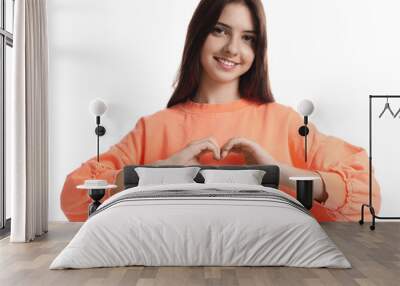 Teenage girl making heart of hands on white background Wall mural