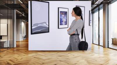 Thoughtful young woman at exhibition in art gallery Wall mural