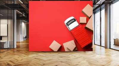 Top view of toy truck with boxes on red background. Logistics and wholesale concept Wall mural