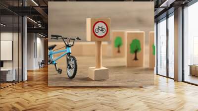 Traffic sign No cycling and toy bicycle on wooden table. Passing driving license exam Wall mural