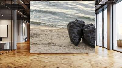 Trash bags full of garbage on beach. Space for text Wall mural