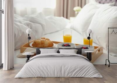 Tray with tasty breakfast on bed in light room Wall mural