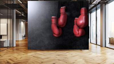 Two pairs of boxing gloves hanging against dark background Wall mural