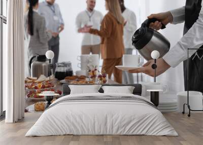 Waitress pouring hot drink during coffee break, closeup Wall mural