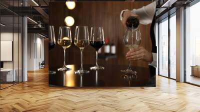 Waitress pouring wine into glass in restaurant, closeup Wall mural