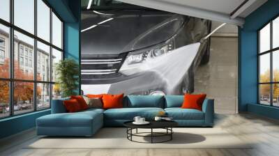 Washing auto with high pressure water jet at car wash, closeup Wall mural