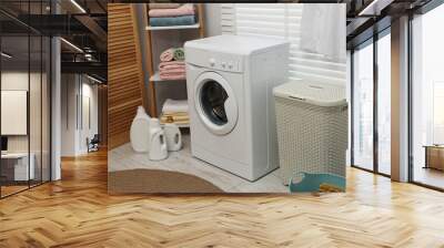 Washing machine, detergents, towels and basket in laundry room Wall mural