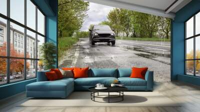 Wet suburban road with car on rainy day Wall mural