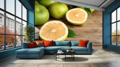 Whole and cut sweetie fruits on wooden table Wall mural