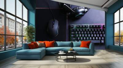 Wired mouse, mousepad, computer keyboard and headset on black table, flat lay Wall mural