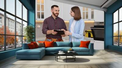 Woman and repairman signing documents near oven in kitchen Wall mural