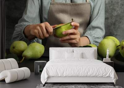 Woman cutting fresh ripe pear at black table, closeup Wall mural