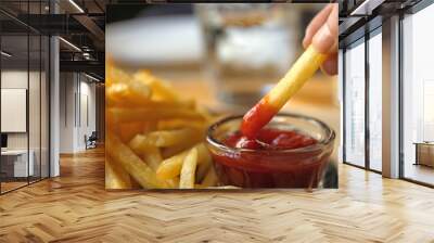 Woman dipping French fries into red sauce in cafe, closeup Wall mural