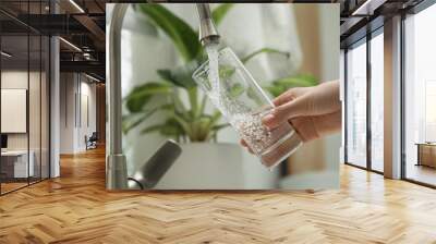 Woman filling glass with water from tap at home, closeup Wall mural