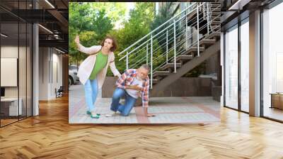 Woman helping mature man suffering from heart attack, outdoors Wall mural