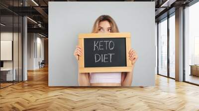 Woman holding blackboard with phrase Keto Diet on grey background Wall mural