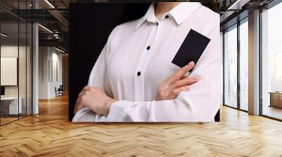 Woman holding blank business card on black background, closeup. Space for text Wall mural