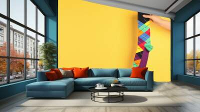 Woman holding bright sock and space for design on color background Wall mural