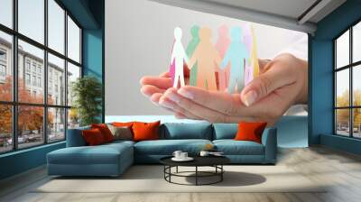 Woman holding paper human figures at table, closeup. Diversity and Inclusion concept Wall mural