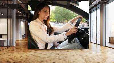 Woman holding steering wheel while driving car Wall mural