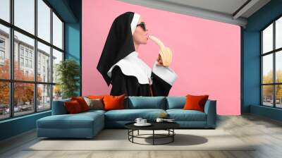 Woman in nun habit with banana against pink background, space for text. Sexy costume Wall mural