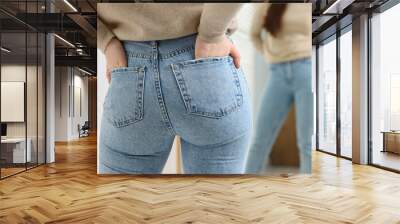 Woman in stylish jeans near mirror indoors, closeup Wall mural