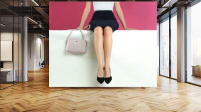 Woman in stylish shoes sitting on color background, closeup Wall mural