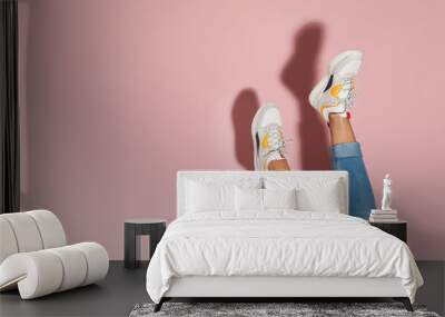 Woman in stylish sneakers near color wall, closeup. Space for text Wall mural