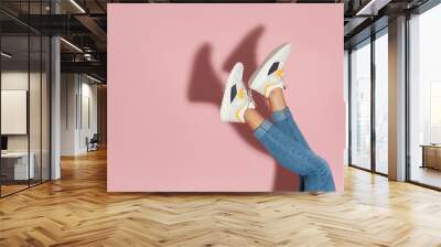 Woman in stylish sneakers near color wall, closeup. Space for text Wall mural