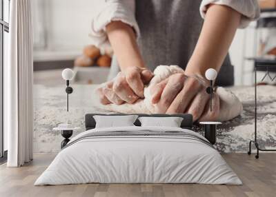 Woman kneading dough at table in kitchen, closeup Wall mural