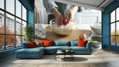 Woman making dough at white wooden table in kitchen, closeup Wall mural