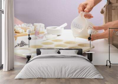 Woman making hand made soap bar with lavender flowers at table, closeup Wall mural