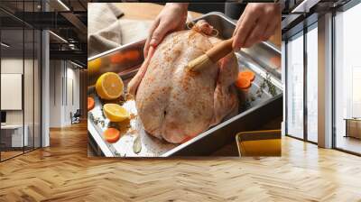 Woman marinating whole turkey at table, closeup Wall mural