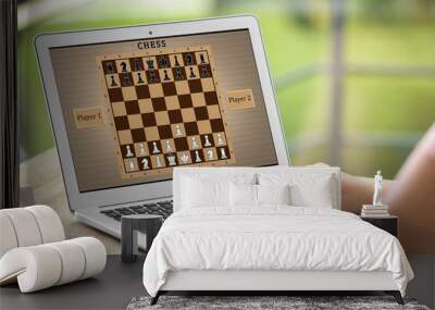 Woman playing online chess on laptop at table, closeup Wall mural