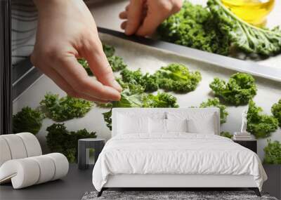 Woman preparing kale chips at table, closeup Wall mural