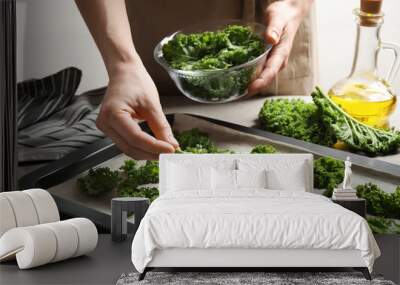 Woman preparing kale chips at table, closeup Wall mural