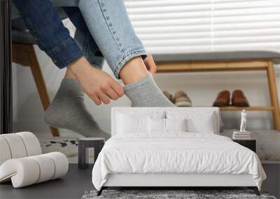 Woman putting on grey socks at home, closeup Wall mural