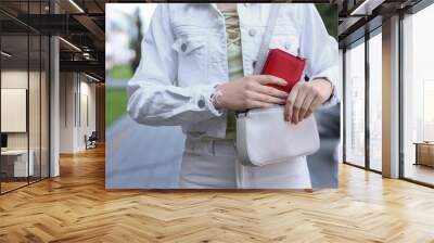 Woman putting purse into bag outdoors, closeup Wall mural