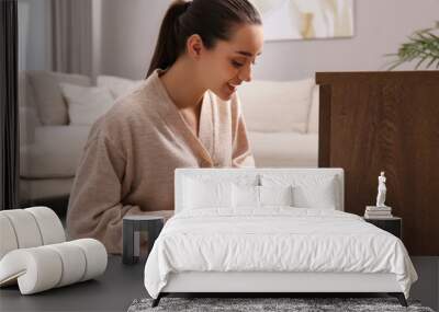 Woman putting scented sachet into drawer with clothes Wall mural