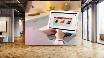 Woman shopping online during sale on laptop in kitchen, closeup Wall mural