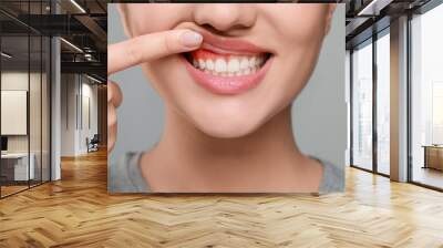 Woman showing inflamed gum on grey background, closeup Wall mural