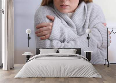 Woman suffering from cold on blurred background Wall mural