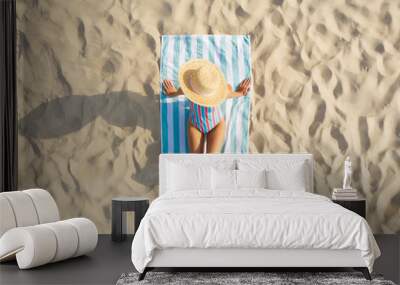 Woman sunbathing on beach towel at sandy coast, aerial view Wall mural