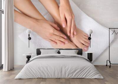 Woman touching her smooth feet on white towel, closeup. Spa treatment Wall mural